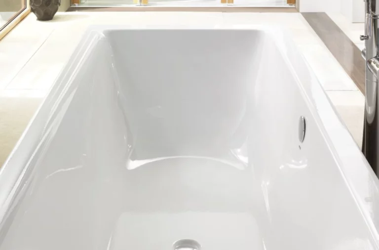 Rechteckige Badewanne aus Stahl-Email, weiß, mit glatten Kanten und mittlerem Ablauf, modernes Badezimmerumfeld.