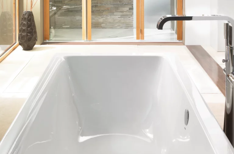 Rechteckige Badewanne aus Stahl-Email, weiß, mit glatten Kanten und mittlerem Ablauf, modernes Badezimmerumfeld.