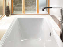 Rechteckige Badewanne aus Stahl-Email, weiß, mit glatten Kanten und mittlerem Ablauf, modernes Badezimmerumfeld.