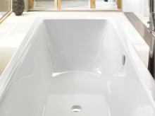 Rechteckige Badewanne aus Stahl-Email, weiß, mit glatten Kanten und mittlerem Ablauf, modernes Badezimmerumfeld.