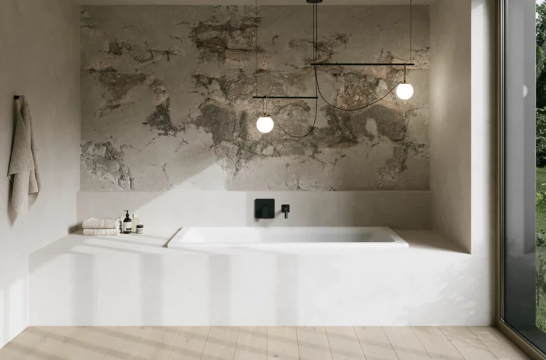 Minimalistisches Bad mit weißer eingelassener Badewanne, grauer Wandstruktur, Pendelleuchten und großem Fenster.