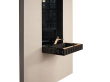 Современная прямоугольная раковина из стальной эмали на черной столешнице перед грубой стеной, большой зеркало сзади.