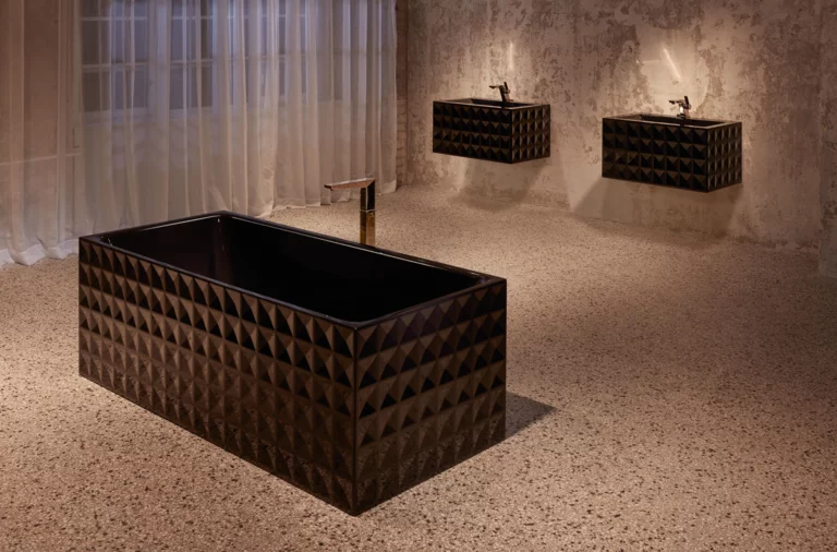 Bañera rectangular de acero esmaltado y dos lavabos sobre encimeras, cada uno con diseño geométrico.