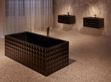 Bañera rectangular de acero esmaltado y dos lavabos sobre encimeras, cada uno con diseño geométrico.