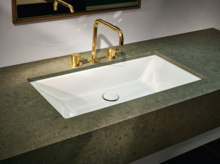 Rechteckiges Stahl-Email-Waschbecken in Einbauplatte, goldene Armatur, modernes Design, heller Hintergrund.