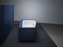 Rechteckige Badewanne aus Stahl-Email, in blauer Verkleidung, freistehend in modernem, minimalistischem Badezimmer.