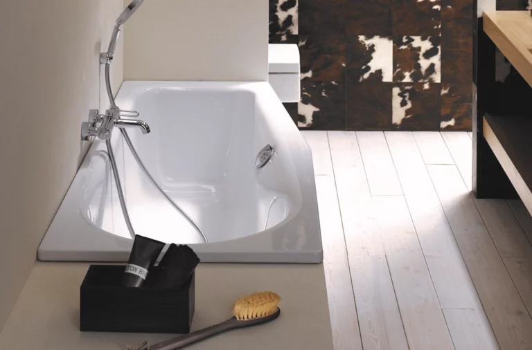 Vasca da bagno rettangolare in acciaio smaltato con rubinetteria, incassata in una superficie chiara, bagno moderno.