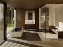 Salle de bains spacieuse avec baignoire encastrée sombre, paroi vitrée, douche de plain-pied, double vasque et vue sur la verdure.