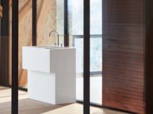 Современная прямоугольная раковина из стальной эмали на столешнице с смесителем в светлом помещении.