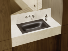 Современная матовая чёрная раковина в светлой консоли с настенным смесителем, окружена деревянными поверхностями.