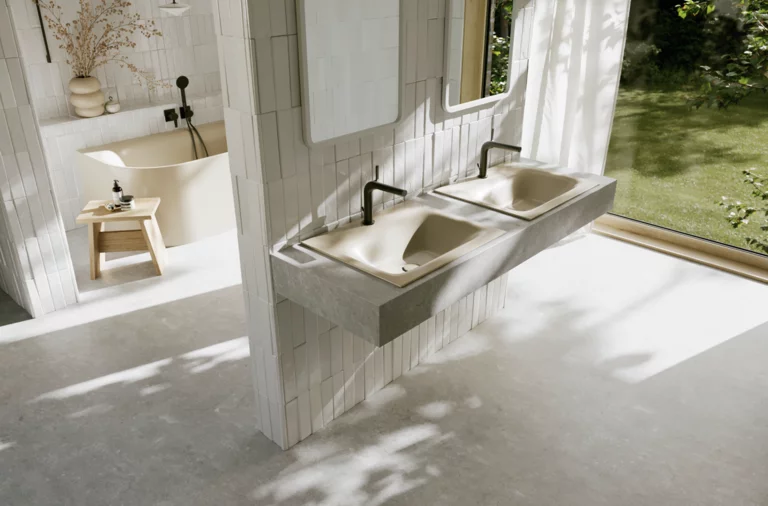 Helles Badezimmer mit zwei beigen Waschtischen, schwarzen Armaturen, großer Fensterfront und Blick in den grünen Garten.