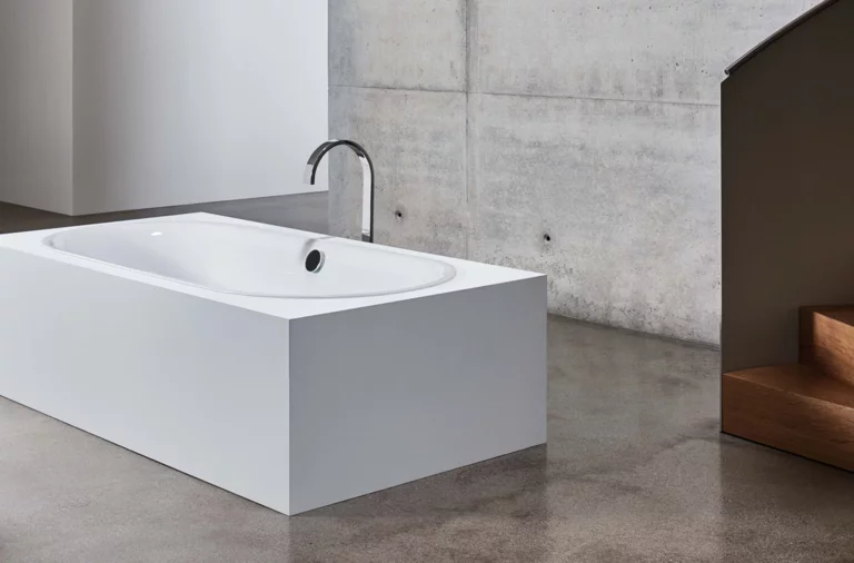 Bañera rectangular exenta de acero esmaltado con interior redondeado en baño moderno sobre suelo de hormigón.