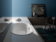 Weiße, ovale Badewanne aus Stahl-Email, in eine weiße Platte eingelassen, modernes Badezimmer mit Dekoration.