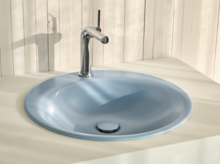 Ovales Waschbecken aus Stahl-Email in Einbauplatte mit glänzender Armatur vor heller Holzverkleidung.