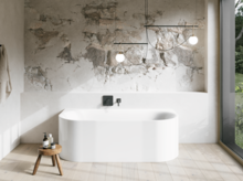 Weiße Badewanne in hellem Bad mit Steinoptik-Wand, schwarzer Armatur, Pendelleuchten und großem Fenster.
