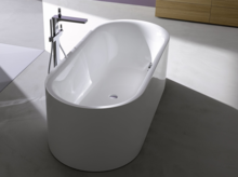 独立椭圆形钢搪瓷浴缸配现代落地龙头，位于明亮浴室内。