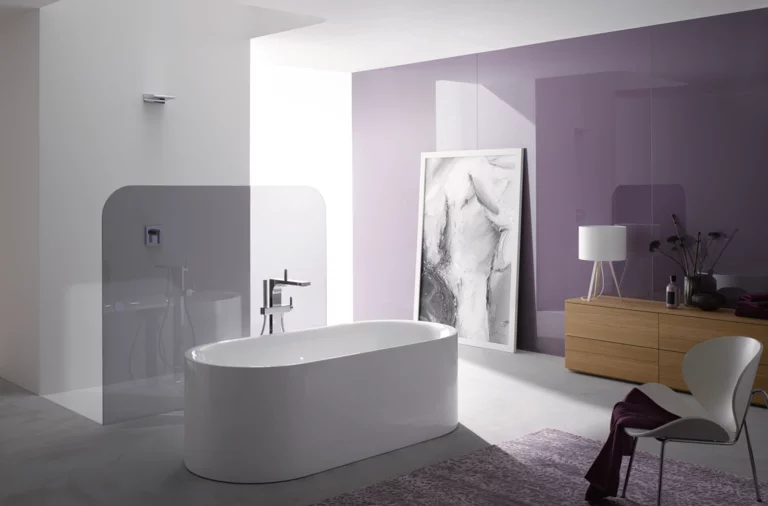 Vrijstaand ovaal bad van staal-email in moderne badkamer met paarse muur en minimalistisch design.