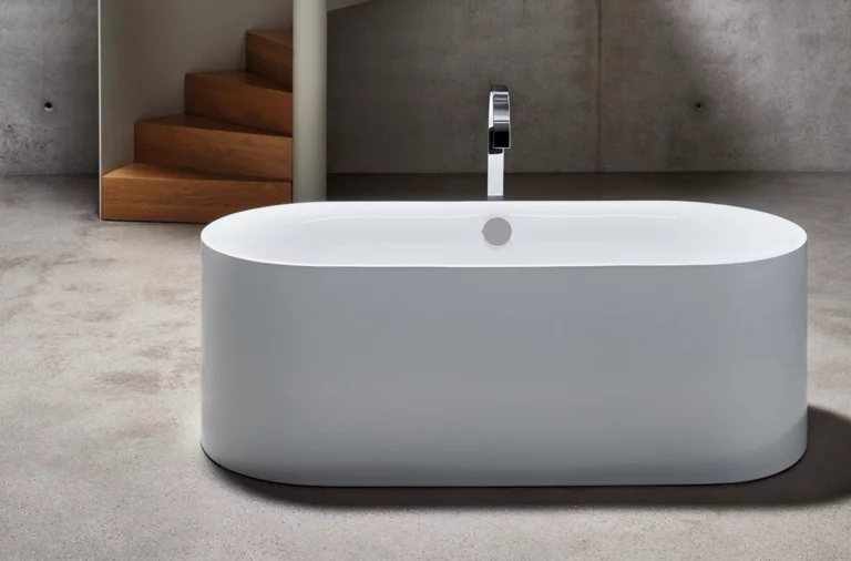 Vrijstaand, ovaal bad van staal-email met middenafvoer in moderne, minimalistische badkamer.