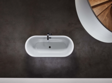 深色地面上的独立椭圆形搪瓷钢浴缸，俯视图