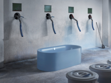 独立椭圆形浅蓝色钢搪瓷浴缸，置于工业风空间。