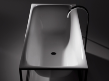 Rectangular steel enamel bathtub with rounded corners on a frame, modern freestanding faucet.