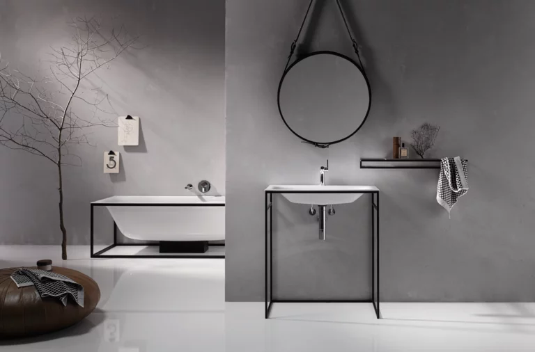 Rechteckige Stahl-Email-Badewanne und rechteckiges Stahl-Email-Waschbecken auf Einbauplatte, modernes Bad in Grau.