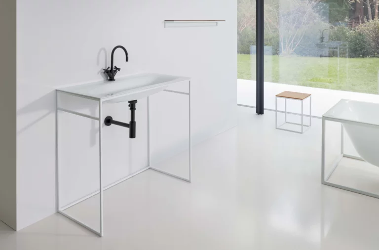 Waschbecken aus Stahl-Email auf rechteckiger Einbauplatte, freistehende rechteckige Badewanne aus Stahl-Email, minimalistisches Badezimmer.