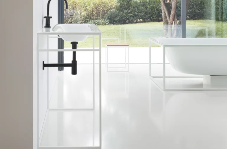 Waschbecken aus Stahl-Email auf Einbauplatte, freistehende oval geformte Badewanne aus Stahl-Email im modernen Badezimmer.