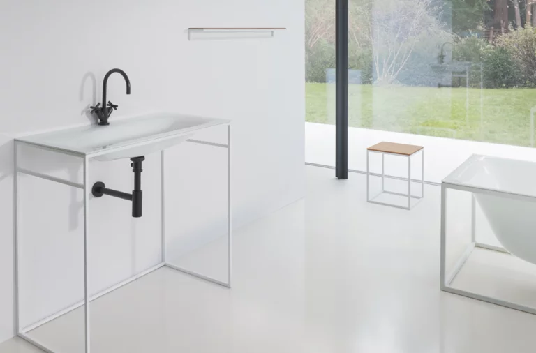 Waschbecken aus Stahl-Email auf Einbauplatte, rechteckige Badewanne aus Stahl-Email, modernes, barrierefreies Bad mit Blick ins Grüne.