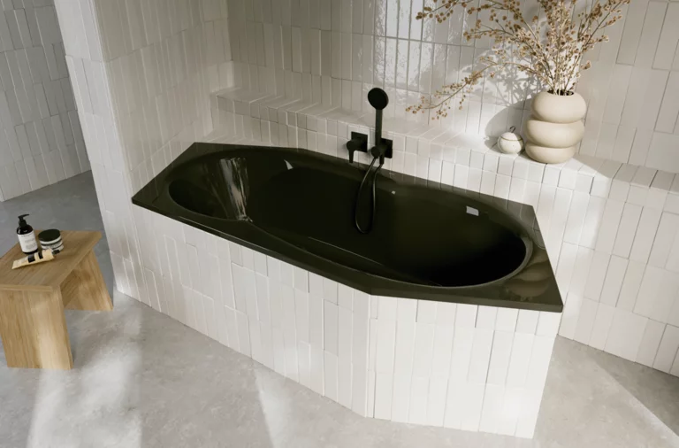 Dunkle Einbau-Badewanne in hell gefliester Ecke, mit schwarzer Armatur, Beistelltisch und Vase mit Zweigen.