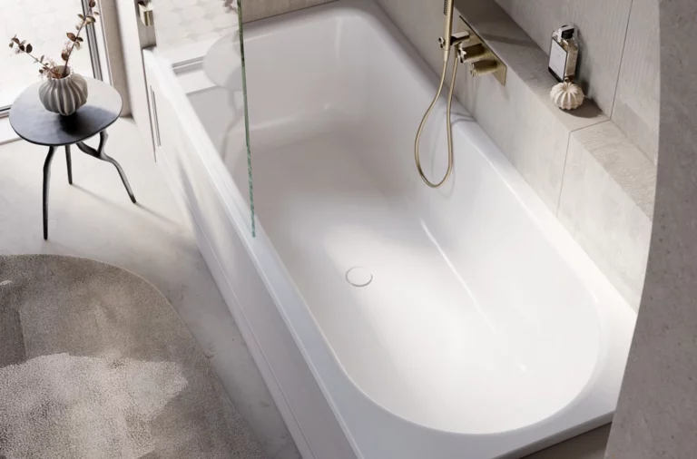 Baignoire-douche moderne avec paroi vitrée, robinet doré et fenêtre latérale donnant sur balcon et sol carrelé.