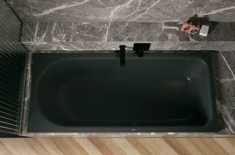 Dunkle Badewanne in grauer Nische, von oben gesehen, mit schwarzer Armatur und hellem Fischgrätboden.