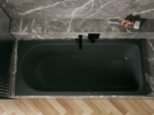 Dunkle Badewanne in grauer Nische, von oben gesehen, mit schwarzer Armatur und hellem Fischgrätboden.
