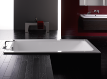 Rechteckige Badewanne aus Stahl-Email und rechteckiges Waschbecken auf Einbauplatte in modernem Badezimmer.