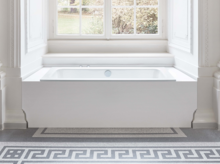 Baignoire rectangulaire en acier émaillé, intégrée dans un espace lumineux devant une grande fenêtre, architecture classique.