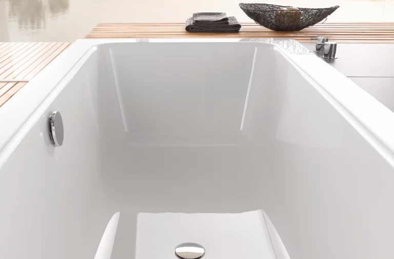 Rechteckige Badewanne aus Stahl-Email, weiß, mit Ablage aus Holz und modernem, minimalistischem Design.