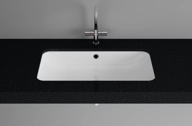 Rectangular steel enamel washbasin in countertop, centrally mounted faucet below, classic design.