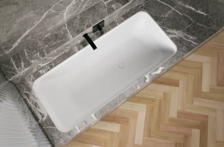 Weiße Badewanne in grauer Nische, schräg von oben gesehen, mit schwarzer Armatur und hellem Fischgrätboden.