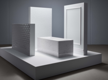 Rechteckige Badewanne aus Stahl-Email, freistehend auf Podest, umgeben von strukturierten weißen Wandplatten.