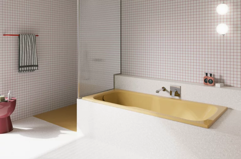 Gelbe Badewanne in hell gefliestem Bad mit Duschbereich, Wandarmatur und rosa Hocker.