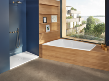 Прямоугольная стальная эмалированная ванна и плоский прямоугольный стальной эмалированный душевой поддон в современной ванной комнате с деревянной отделкой.