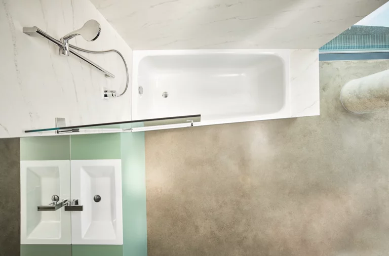 Rechteckige Badewanne aus Stahl-Email und zwei eckige Waschbecken auf Einbauplatte in modernem Bad.