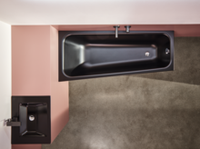 Vasca da bagno rettangolare nera in acciaio smaltato e lavabo squadrato su piano d’appoggio, vista moderna del bagno dall’alto.