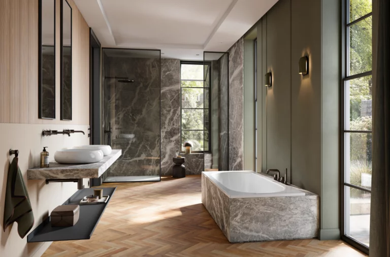 Großzügiges Bad mit Badewanne, Dusche und Doppelwaschtisch, Marmorflächen, Fischgrätparkett und großen Fenstern.