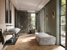 Großzügiges Bad mit Badewanne, Dusche und Doppelwaschtisch, Marmorflächen, Fischgrätparkett und großen Fenstern.