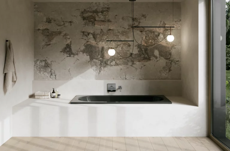 Dunkle Badewanne in hellem Bad mit weißer Einfassung, strukturierter Wand, Pendelleuchten und großem Fenster.