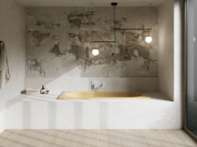 Gelbe Badewanne in hellem Bad mit weißer Einfassung, strukturierter Wand, Pendelleuchten und großem Fenster.
