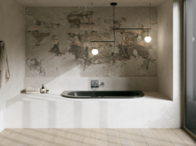 Donker bad in lichte badkamer met witte ombouw, gestructureerde wand, hanglampen en groot raam.