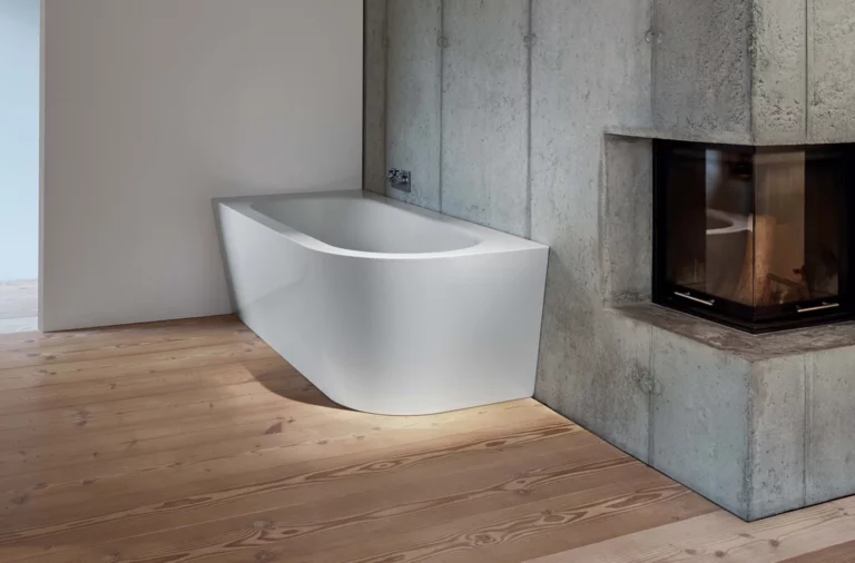 Freistehende, rechteckige Badewanne aus Stahl-Email mit abgerundeter Vorderseite in modernem Badezimmer mit Kamin.