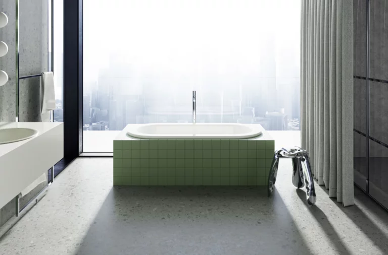 Eingelassene Badewanne mit grüner Fliesenverkleidung vor bodentiefem Fenster mit Blick auf eine nebelverhangene Stadt.